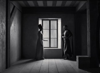 Movie still from “The Tragedy of Macbeth” (2021), directed by Joel Coen – Two people in a room looking out of a window; Wide shot, Low angle