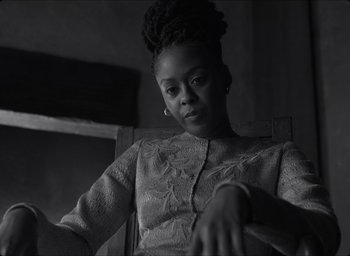Movie still from “The Tragedy of Macbeth” (2021), directed by Joel Coen – A black and white photo of a woman sitting in a chair; Close Up shot, Low angle