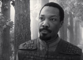 Movie still from “The Tragedy of Macbeth” (2021), directed by Joel Coen – A black and white photo of a man with a beard; Close Up shot, Over the shoulder angle