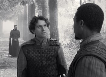 Movie still from “The Tragedy of Macbeth” (2021), directed by Joel Coen – Two men in medieval garb talking in the woods; Medium shot, Over the shoulder angle