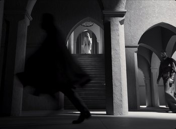 Movie still from “The Tragedy of Macbeth” (2021), directed by Joel Coen – A man walking down a staircase in a building; Extreme Wide shot, Low angle