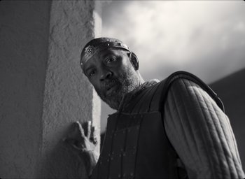 Movie still from “The Tragedy of Macbeth” (2021), directed by Joel Coen – Black and white photograph of a man wearing a medieval outfit; Medium shot, Low angle
