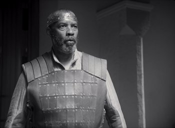 Movie still from “The Tragedy of Macbeth” (2021), directed by Joel Coen – Black and white photograph of a man in a costume; Medium shot, Low angle