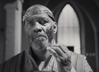Movie still from “The Tragedy of Macbeth” (2021), directed by Joel Coen – An older man with a beard and a turban on; Close Up shot, Low angle