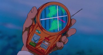 Movie still from “The Transformers: The Movie” (1986), directed by Nelson Shin – A hand holding a cell phone with a map of the world on it; Extreme Close Up shot, High angle