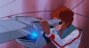 Movie still from “The Transformers: The Movie” (1986), directed by Nelson Shin – A man is looking through a computer screen; Medium shot, Low angle