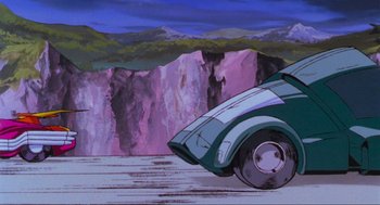 Movie still from “The Transformers: The Movie” (1986), directed by Nelson Shin – An old car is parked on the side of a mountain; Wide shot, High angle