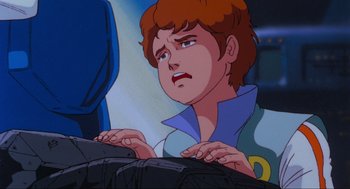 Movie still from “The Transformers: The Movie” (1986), directed by Nelson Shin – A cartoon of a boy looking sad while sitting at a desk; Close Up shot, Over the shoulder angle
