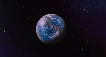 Movie still from “The Transformers: The Movie” (1986), directed by Nelson Shin – An image of an earth in the middle of the night sky; Extreme Wide shot, Low angle