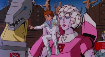 Movie still from “The Transformers: The Movie” (1986), directed by Nelson Shin – A man sitting on top of a woman's lap; Wide shot, Low angle