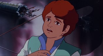 Movie still from “The Transformers: The Movie” (1986), directed by Nelson Shin – A young man with red hair is looking at the camera; Close Up shot, High angle