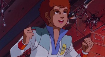 Movie still from “The Transformers: The Movie” (1986), directed by Nelson Shin – A cartoon of a boy with red hair and a blue shirt; Medium shot, Low angle