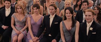 Movie still from “The Twilight Saga: Breaking Dawn - Part 1” (2011), directed by Bill Condon – A man sitting between two women in formal wear; Medium shot, High angle