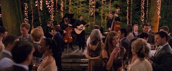 Movie still from “The Twilight Saga: Breaking Dawn - Part 1” (2011), directed by Bill Condon – A group of people standing around a room with musical instruments; Wide shot, Over the shoulder angle