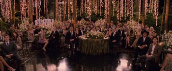 Movie still from “The Twilight Saga: Breaking Dawn - Part 1” (2011), directed by Bill Condon – A group of people sitting around a table with flowers on it; Wide shot, High angle