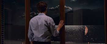 Movie still from “The Twilight Saga: Breaking Dawn - Part 1” (2011), directed by Bill Condon – A man standing next to a pole in front of a painting; Medium shot, Over the shoulder angle