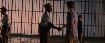 Movie still from “The Twilight Saga: Breaking Dawn - Part 1” (2011), directed by Bill Condon – Two men shake hands in front of a jail cell; Medium shot, Over the shoulder angle