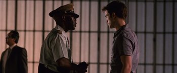 Movie still from “The Twilight Saga: Breaking Dawn - Part 1” (2011), directed by Bill Condon – Two men are standing next to each other in front of bars; Medium shot, Over the shoulder angle