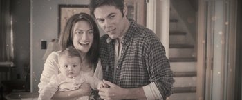 Movie still from “The Twilight Saga: Breaking Dawn - Part 1” (2011), directed by Bill Condon – A man and a woman holding a baby in her arms; Medium shot, High angle