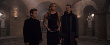 Movie still from “The Twilight Saga: Breaking Dawn - Part 1” (2011), directed by Bill Condon – A woman in a black dress holding a tray in front of three men; Medium shot, Low angle