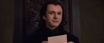 Movie still from “The Twilight Saga: Breaking Dawn - Part 1” (2011), directed by Bill Condon – A man in black shirt holding a piece of paper; Close Up shot, High angle