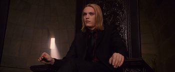 Movie still from “The Twilight Saga: Breaking Dawn - Part 1” (2011), directed by Bill Condon – A man in a suit and tie sitting in a chair; Medium shot, Low angle