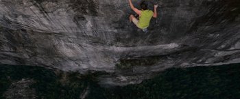 Movie still from “The Twilight Saga: Breaking Dawn - Part 2” (2012), directed by Bill Condon – A man climbing a rock wall on the side of a mountain; Extreme Wide shot, Overhead angle