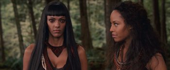 Movie still from “The Twilight Saga: Breaking Dawn - Part 2” (2012), directed by Bill Condon – Two women standing next to each other in the woods; Close Up shot, Over the shoulder angle