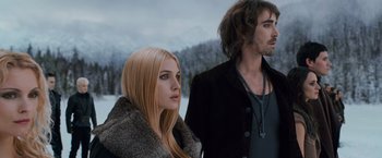 Movie still from “The Twilight Saga: Breaking Dawn - Part 2” (2012), directed by Bill Condon – A woman standing next to a man in a fur coat; Medium shot, Low angle