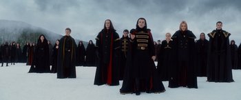 Movie still from “The Twilight Saga: Breaking Dawn - Part 2” (2012), directed by Bill Condon – A group of people dressed in black and red costumes; Wide shot, Low angle