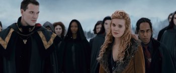 Movie still from “The Twilight Saga: Breaking Dawn - Part 2” (2012), directed by Bill Condon – A group of people standing around a woman in front; Close Up shot, Over the shoulder angle