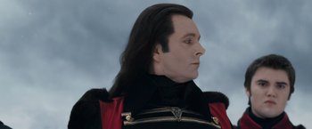 Movie still from “The Twilight Saga: Breaking Dawn - Part 2” (2012), directed by Bill Condon – A person wearing a black and red uniform; Close Up shot, Low angle