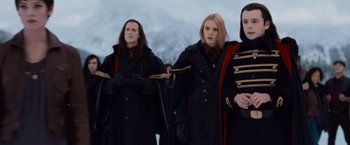 Movie still from “The Twilight Saga: Breaking Dawn - Part 2” (2012), directed by Bill Condon – A group of people standing next to each other wearing coats; Medium shot, Low angle