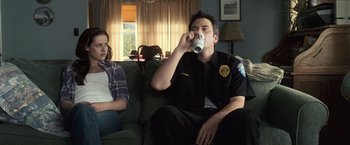 Movie still from “The Twilight Saga: Eclipse” (2010), directed by David Slade – A man and woman sitting on a couch drinking coffee; Medium shot, Over the shoulder angle