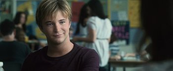 Movie still from “The Twilight Saga: Eclipse” (2010), directed by David Slade – A young man smiles for the camera in front of a woman; Close Up shot, Over the shoulder angle