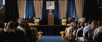 Movie still from “The Twilight Saga: Eclipse” (2010), directed by David Slade – A woman standing at a podium in front of a group of people; Wide shot, High angle