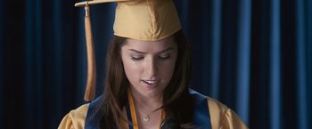 Movie still from “The Twilight Saga: Eclipse” (2010), directed by David Slade – A woman wearing a graduation cap and holding a microphone; Close Up shot, Overhead angle