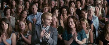 Movie still from “The Twilight Saga: Eclipse” (2010), directed by David Slade – A group of people sitting in a room clapping; Medium shot, Over the shoulder angle