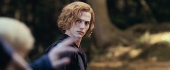 Movie still from “The Twilight Saga: Eclipse” (2010), directed by David Slade – A man with long blonde hair is standing in front of a tree; Close Up shot, Over the shoulder angle