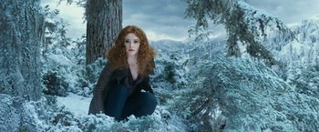 Movie still from “The Twilight Saga: Eclipse” (2010), directed by David Slade – A red haired woman sitting on the ground next to a tree; Medium shot, Low angle