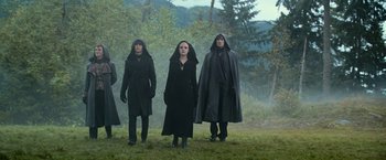 Movie still from “The Twilight Saga: Eclipse” (2010), directed by David Slade – A group of people standing on top of a grass covered field; Wide shot, Low angle