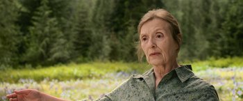 Movie still from “The Twilight Saga: New Moon” (2009), directed by Chris Weitz – An older woman is standing in the grass; Close Up shot, Over the shoulder angle