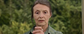 Movie still from “The Twilight Saga: New Moon” (2009), directed by Chris Weitz – An older woman is holding her hands in front of her face; Close Up shot, Low angle