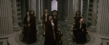 Movie still from “The Twilight Saga: New Moon” (2009), directed by Chris Weitz – A group of people standing in a room with clocks; Wide shot, High angle