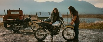 Movie still from “The Twilight Saga: New Moon” (2009), directed by Chris Weitz – Two women are sitting on a motorcycle in the mud; Wide shot, Low angle