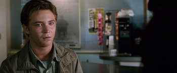 Movie still from “The Twilight Saga: New Moon” (2009), directed by Chris Weitz – A young man in a tan shirt is sitting in front of a counter; Close Up shot, Over the shoulder angle