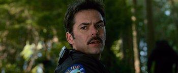 Movie still from “The Twilight Saga: New Moon” (2009), directed by Chris Weitz – A man with a mustache wearing a police uniform; Close Up shot, Low angle