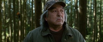 Movie still from “The Twilight Saga: New Moon” (2009), directed by Chris Weitz – An older man in a hat and jacket in the woods; Close Up shot, Low angle