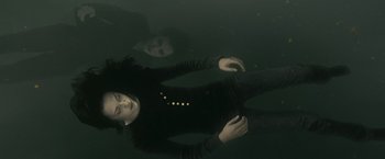 Movie still from “The Twilight Saga: New Moon” (2009), directed by Chris Weitz – A woman in a black shirt is floating in the water; Medium shot, Overhead angle