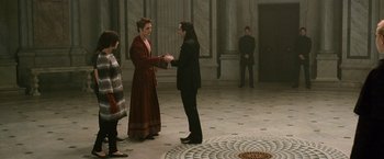 Movie still from “The Twilight Saga: New Moon” (2009), directed by Chris Weitz – Two women and a man are shaking hands in a room; Wide shot, Over the shoulder angle